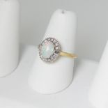 An opal and diamond Ring, the central oval cabochon opal approx 8.25mm x 6.1mm claw set above a