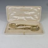 A matched cased pair of silver gilt replica Annointing Spoons, hallmarked London, 1910, one by R & S
