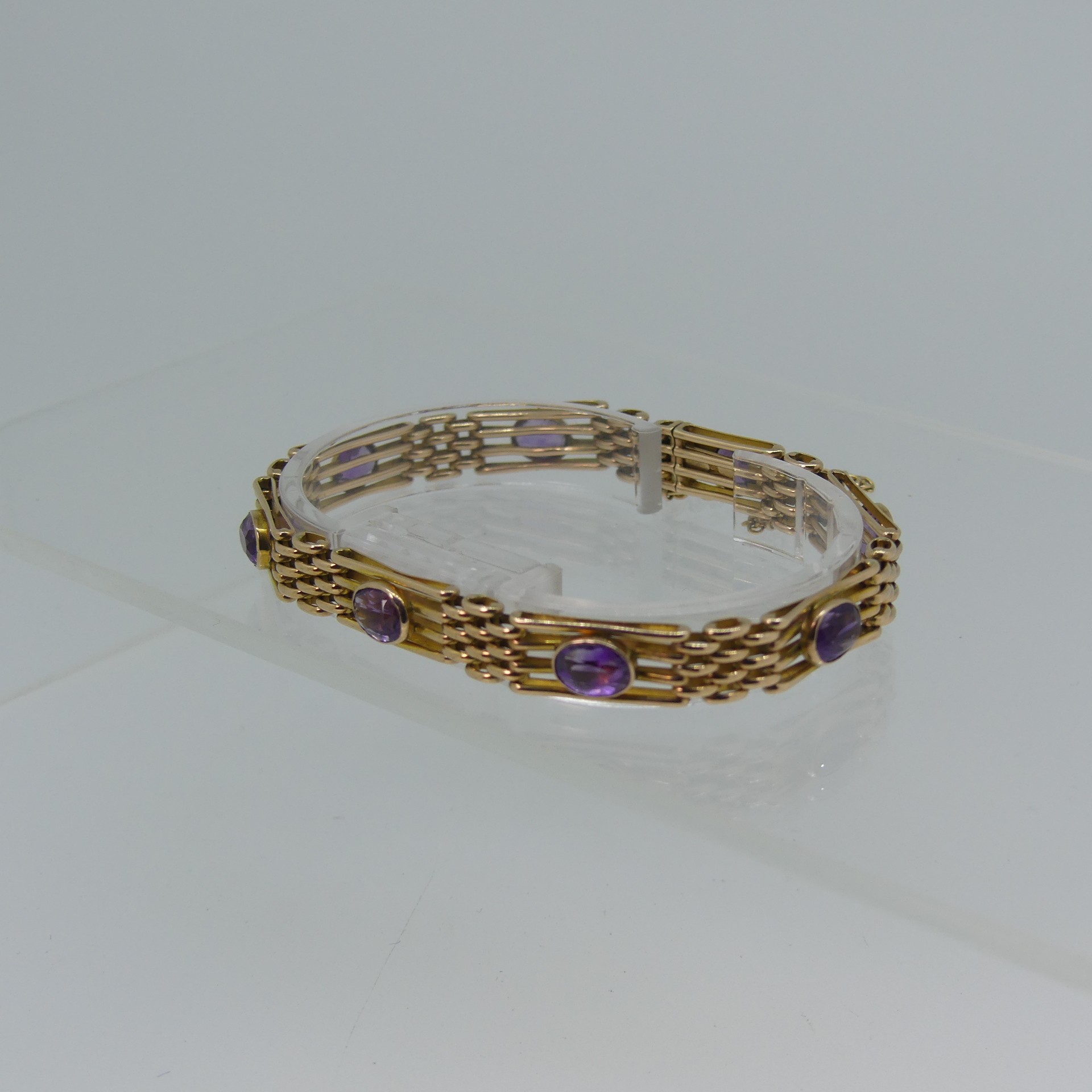 A 9ct yellow gold gatelink Bracelet, set with eight facetted amethysts, one link forming the - Image 3 of 4