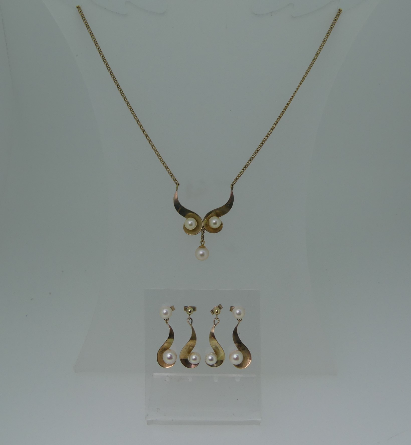 An unmarked gold and cultured pearl Necklace, tests as 9ct, with two pairs of matching earrings,