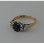 A sapphire and diamond cluster Ring, the central oval facetted sapphire, 7.4mm long, with three