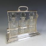 A silver-plated Walker & Hall Tantalus, encasing three cut glass decanters, in a locking "