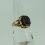 An antique Intaglio Ring, the foiled purple glass stone carved with a stags head crest, the stone
