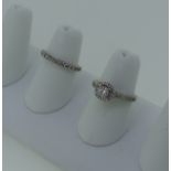 A diamond Ring, the central brilliant cut stone approx 0.4ct, halo set within a border of twelve