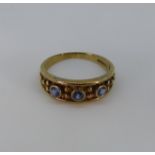 A 9ct gold and sapphire Ring, the three pale sapphires collet set into the textured flared front,