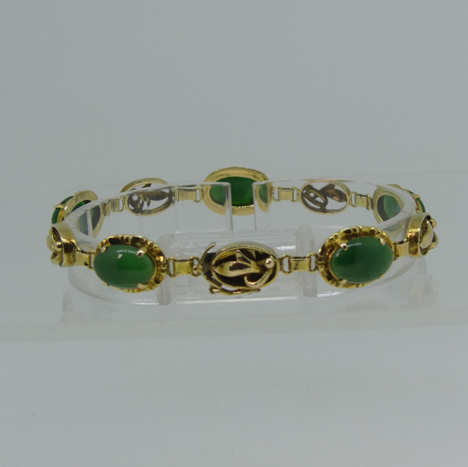 A 14ct yellow gold Bracelet, set with five oval cabochon jades, the integral clasp marked 14k and