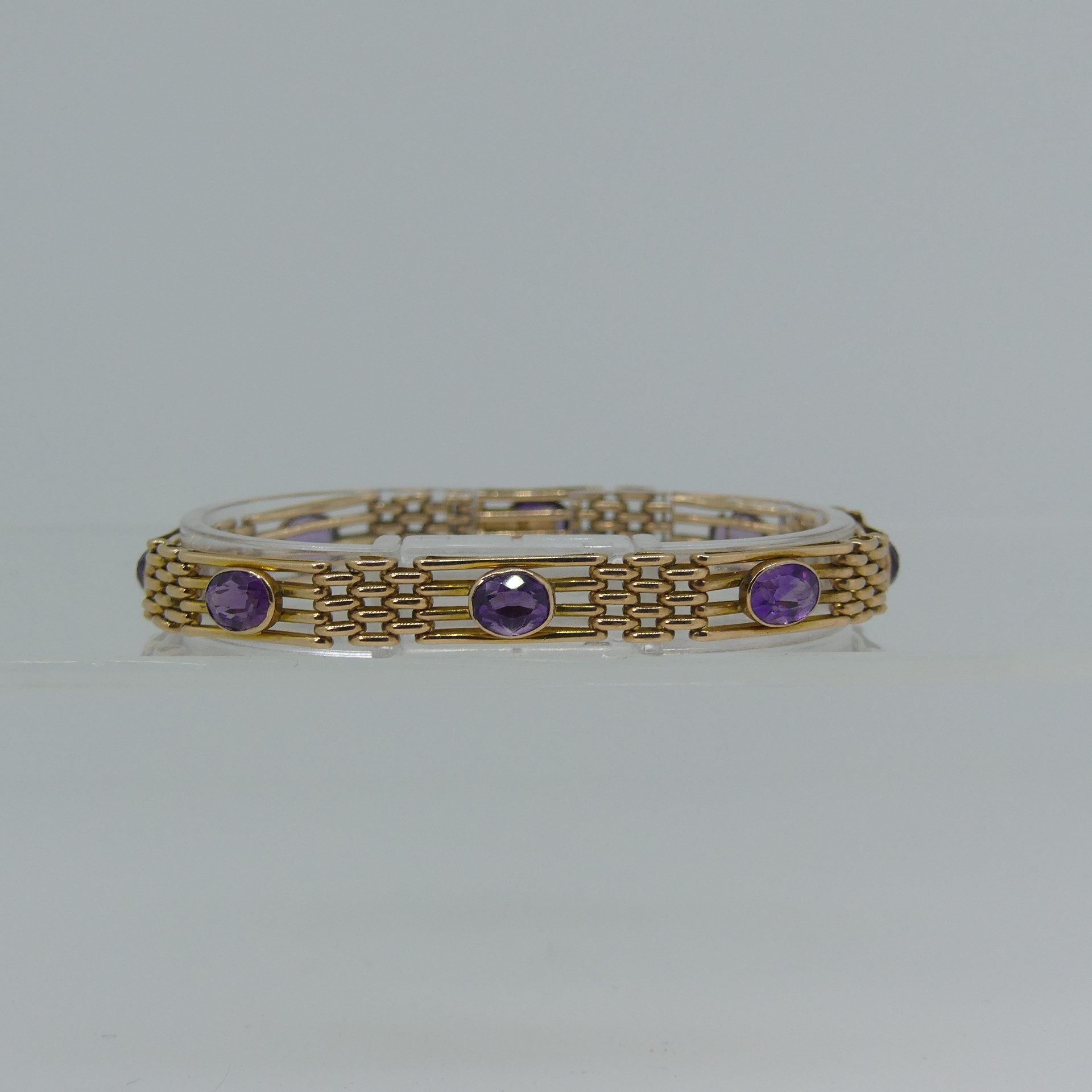 A 9ct yellow gold gatelink Bracelet, set with eight facetted amethysts, one link forming the - Image 2 of 4