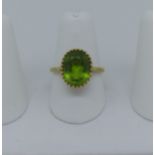 An 18ct yellow gold and peridot Ring, the oval facetted stone 13.25mm x 10.5mm within a pierced