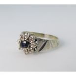 A 9ct white gold sapphire and diamond Ring, the circular facetted sapphire with eight diamond points