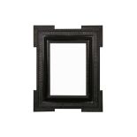A NORTH EUROPEAN 17TH CENTURY STYLE EBONISED BAROQUE RIPPLE FRAME WITH EXTENDED CORNERS