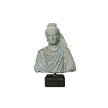 A CARVED GRAY SCHIST BUST OF THE HISTORICAL BUDDHA, SIDDHARTHA GAUTAMA SHAKYAMUNI Ancient region of