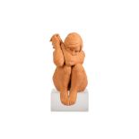 A TERRACOTTA FIGURE IN THE FORM OF A SEATED GIRL