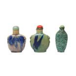 TWO CHINESE FLAMBÉ-GLAZED SNUFF BOTTLES, TOGETHER WITH A GREEN-GLAZED 'LION DOG' SNUFF BOTTLE