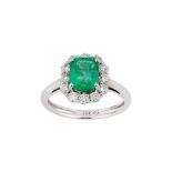 An emerald and diamond cluster ring