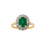 An emerald and diamond cluster ring