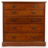 An Edwardian walnut chest of two short over four long drawers, stamped Jas Shoolbred & Co.