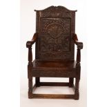 A Charles I walnut and oak wainscot chair, the arch panel back with profusely carved decoration,