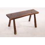 A rectangular rustic elm stool on splay supports, 79cm wide, top 26cm deep,