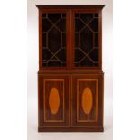 An Edwardian mahogany bookcase, the two glazed doors below inlaid with satinwood ovals, 101.