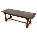 An oak three-plank refectory table, the top supported on a H-stretcher base on turned legs,