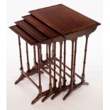 A nest of four mahogany tables banded in satinwood, on twin spindle turned end supports,