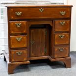 A George III mahogany and inlaid kneehole desk the top with brass three-quarter gallery,