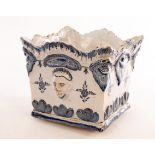 A Delft square planter with moulded mask heads to the sides and foliate decoration,