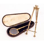 A pair of gold coloured metal pince-nez with spring action and a gilt brass easel watch stand with