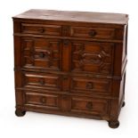 A Charles II oak chest of four long geometric moulded panelled drawers with turned flowerhead