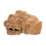 A Chinese earthenware Chimera, Han dynasty, in a lying position and with an open mouth,