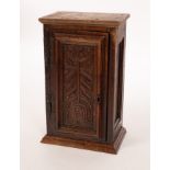 A Charles II carved oak panel with tulip decoration, mounted as a cupboard door,