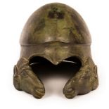 A bronze helmet, after the antique, modelled with cast rams heads under a heart-shaped aperture,