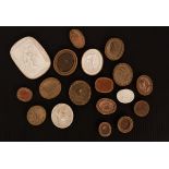 A collection of seventeen Grand Tour plaster intaglios, mostly oval,