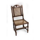 A Charles II walnut cane back side chair with scroll carved cresting and twist turned support legs