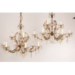 A pair of glass nine-light chandeliers with three upper lights above six lower,