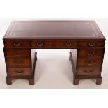 A George III style mahogany pedestal desk with leather lined top and fitted a surround of nine