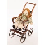 A child's early 20th Century four-wheel pushchair and a rag doll CONDITION REPORT: