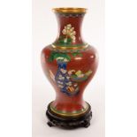 A Cloisonné vase of baluster shape on a wooden stand,
