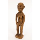 An African carved tribal figure of a grotesque nude on a rectangular base,