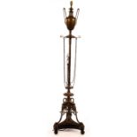 A bronzed metal standard lamp, modelled as an urn on a column with a tripod base,