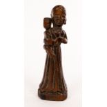 An early Indian tribal carved fruitwood figure of a woman holding a child, set on an oval base, 19.