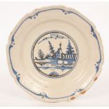 An early 19th Century Dutch blue and white plate decorated buildings, trees and birds,