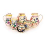 Poole Pottery, three floral jugs, the tallest 20cm high, a floral marmalade pot with raffia handle,