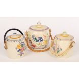 Poole Pottery, three floral biscuit barrels with raffia handles,