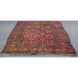 A Turkoman rug with red ground geometric and floral field, within a multi figured border,