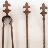 A set of three Arts & Crafts fire irons with fleur-de-lys finials and engraved decoration,