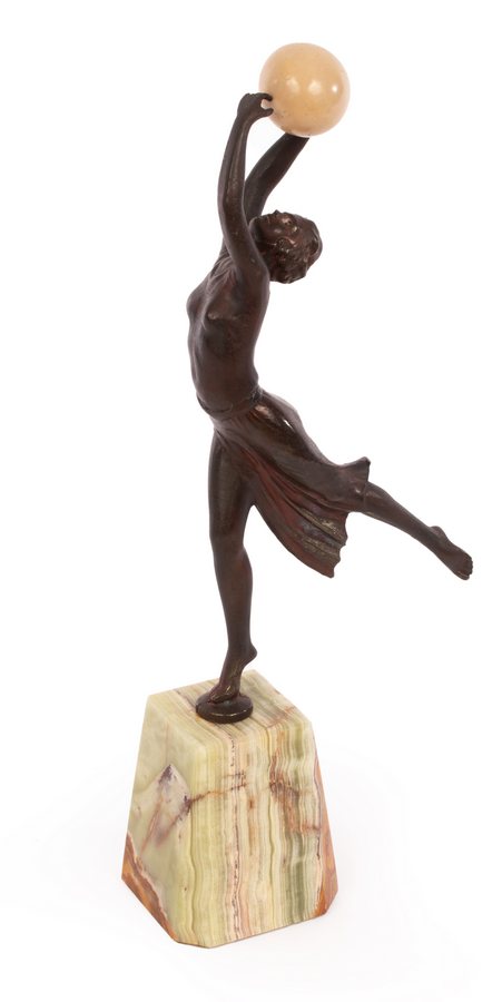 An Art Deco style spelter figure of a dancer holding a resin ball, on an onyx type base, 35.