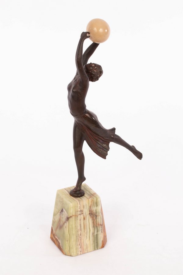 An Art Deco style spelter figure of a dancer holding a resin ball, on an onyx type base, 35. - Image 2 of 4