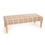 A modern upholstered bench seat, covered in pastel tartan fabric,