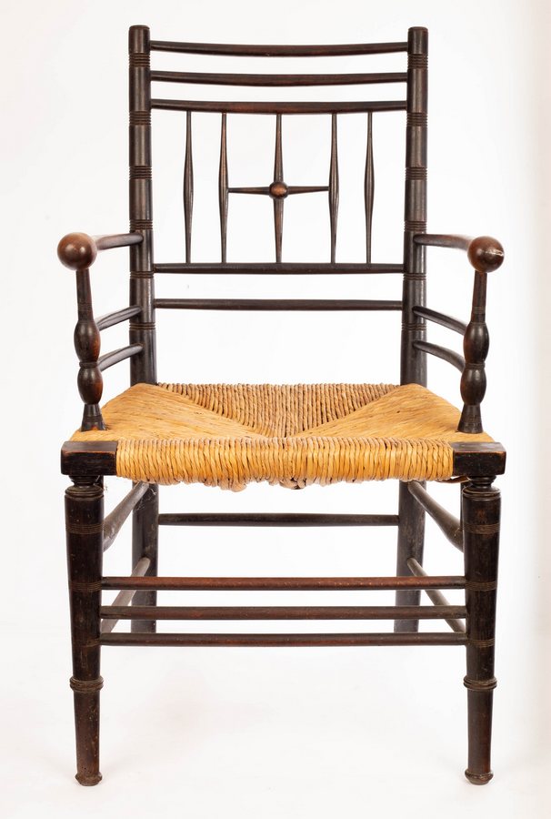 A Liberty Argyll armchair, circa 1880, with ebonised frame and rush seat,